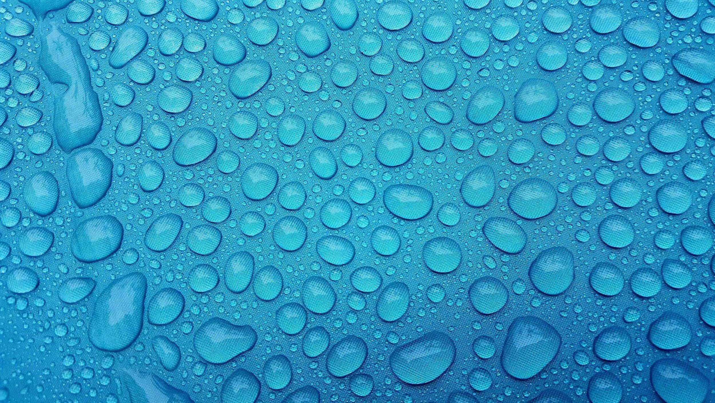 Wassertropfen in verschiedenen Größen auf azurblauem Hintergrund